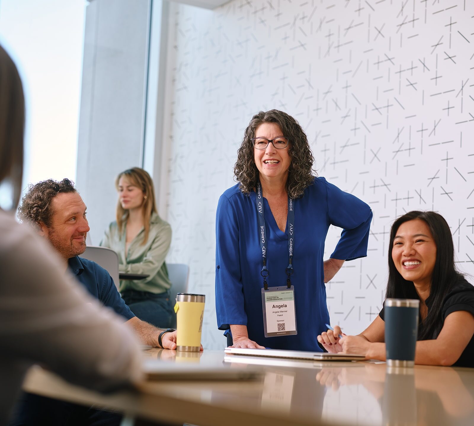 a group of people working around a table, smiling